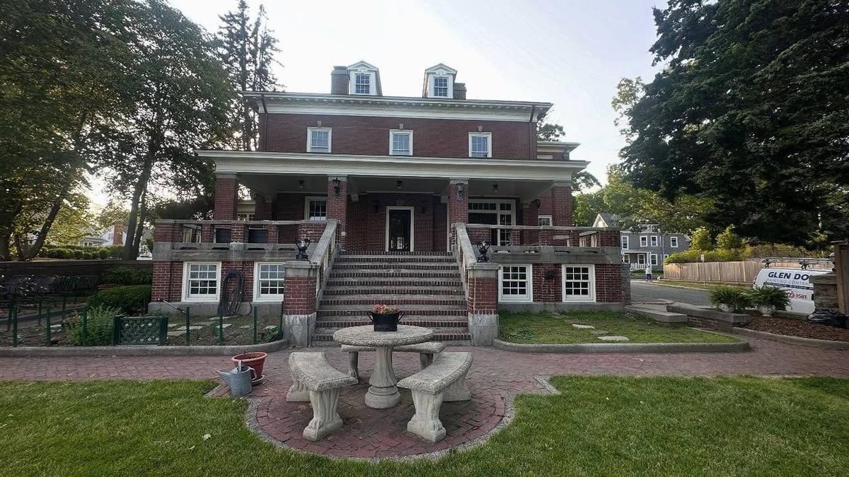 Historic brick mansion with restored white trim, columns and dormers