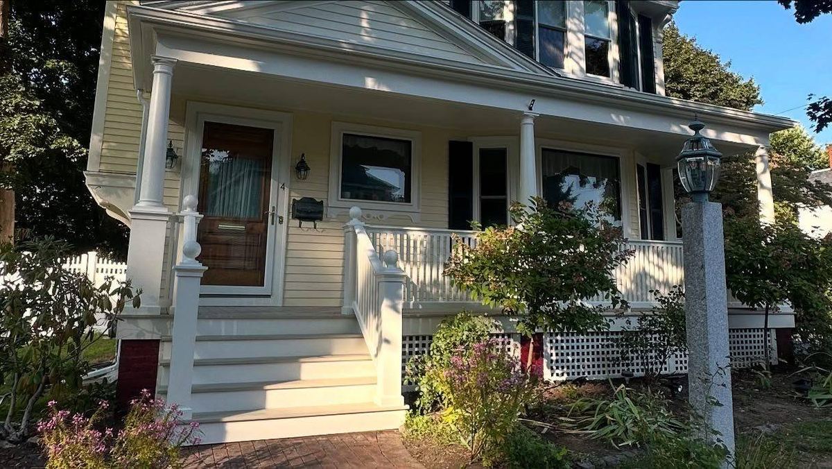 Cream colonial front porch with freshly painted white columns and railings